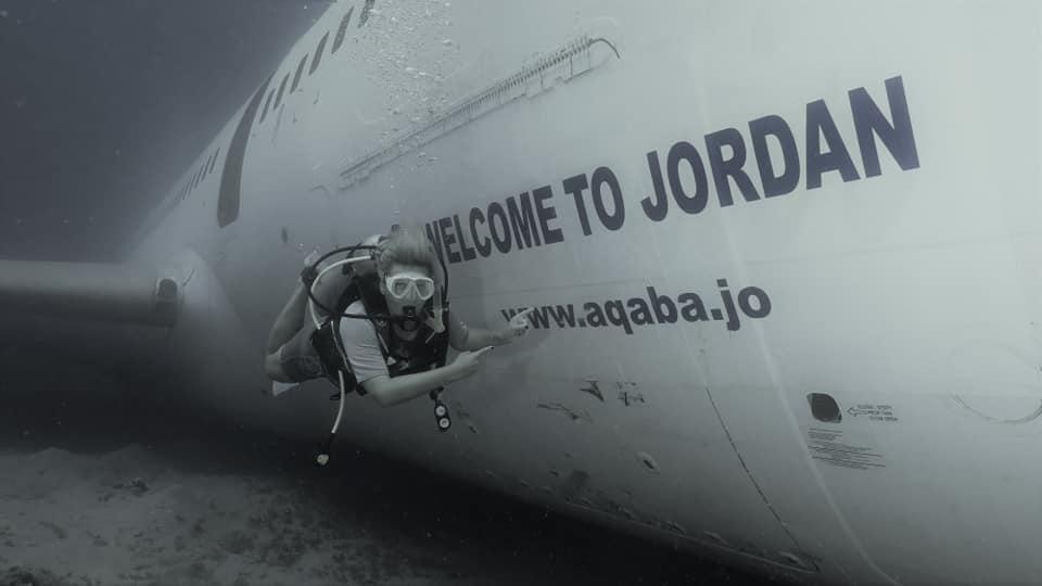 A diver poses beside the sunken 'Welcome to Jordan' airplane wreck near Aqaba