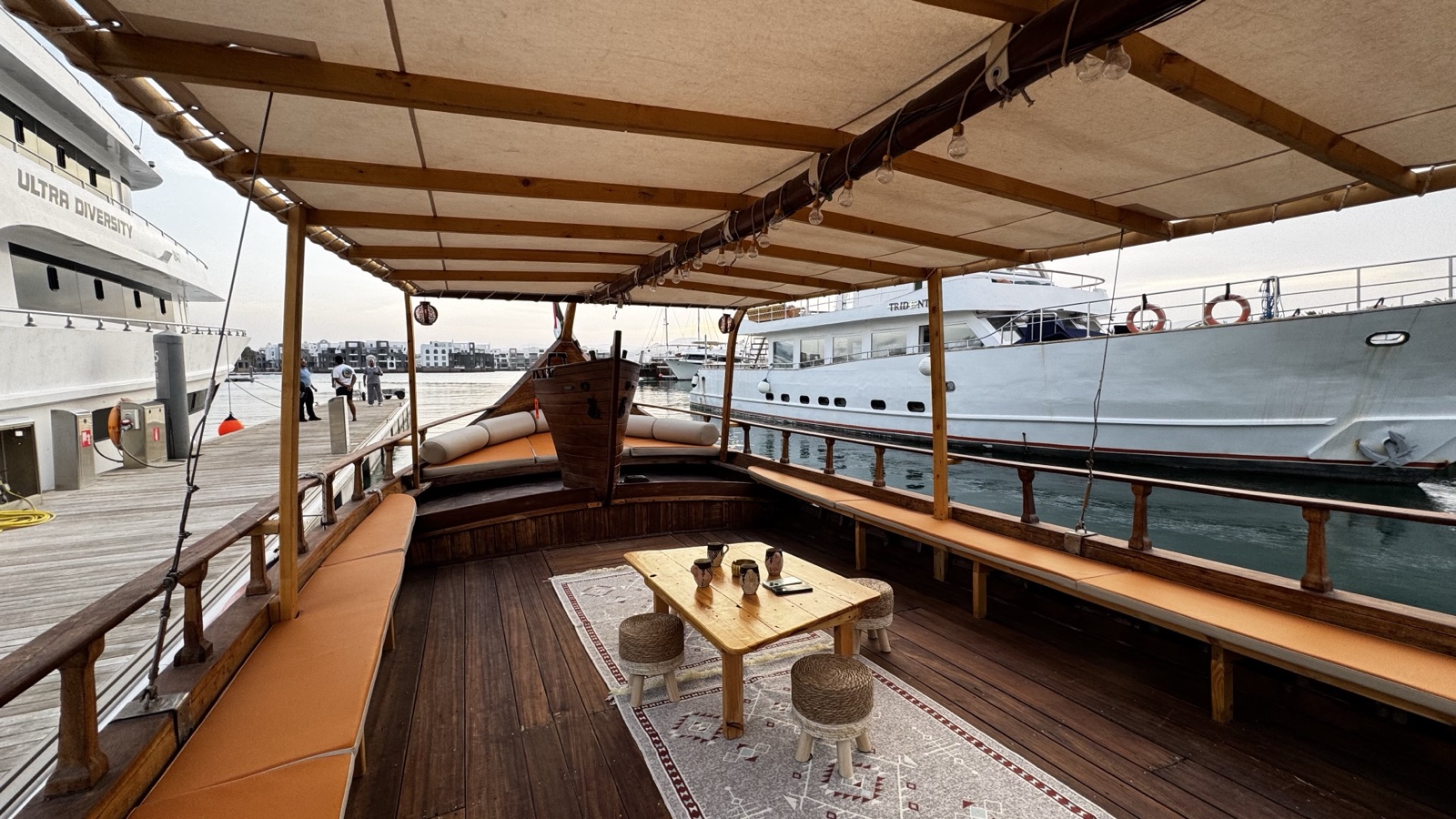 The shaded lounge deck of the Alissar, with cushioned bench seating and a low wooden table